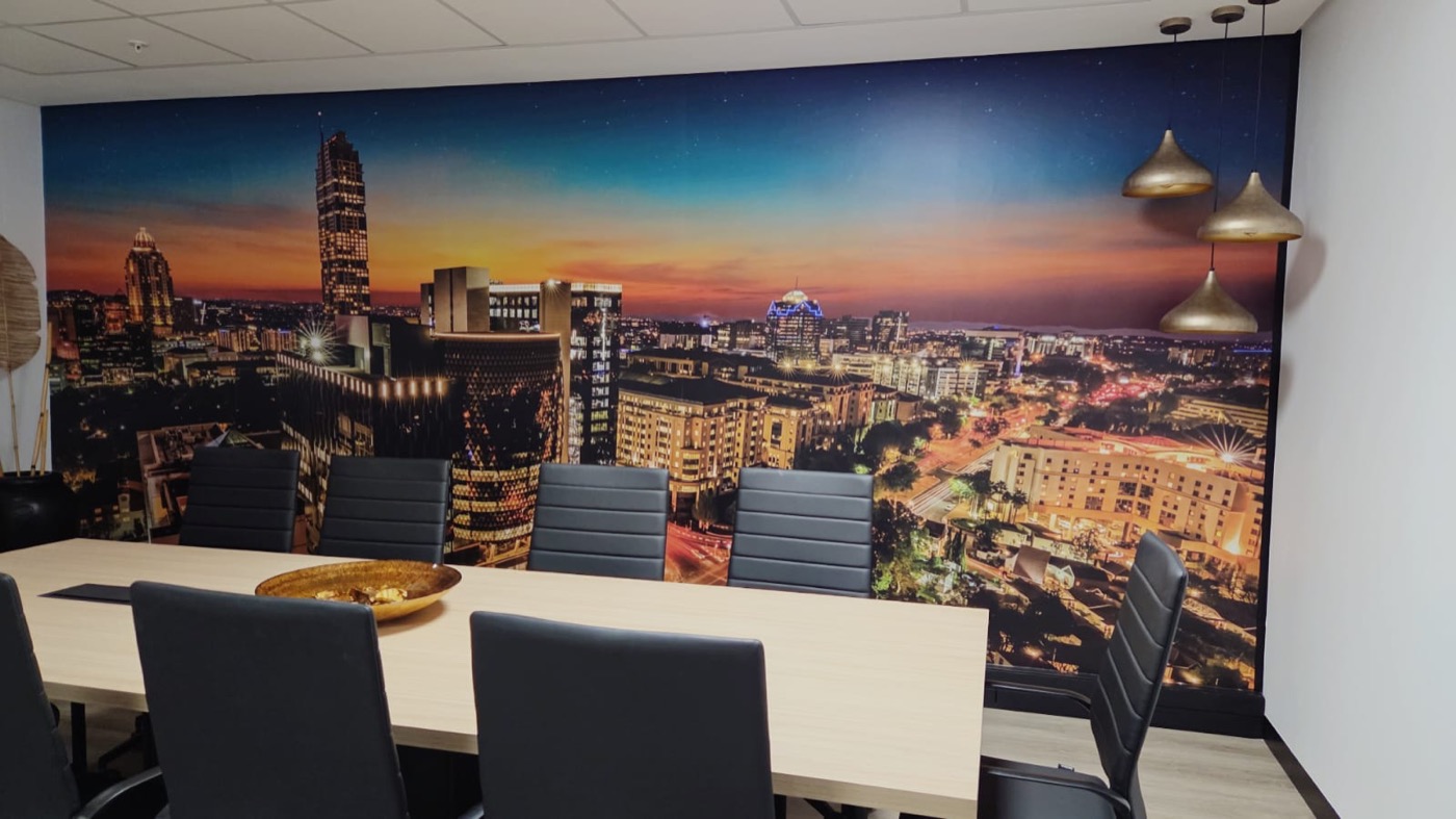 Completed boardroom with Johannesburg skyline wallpaper and black leather seating